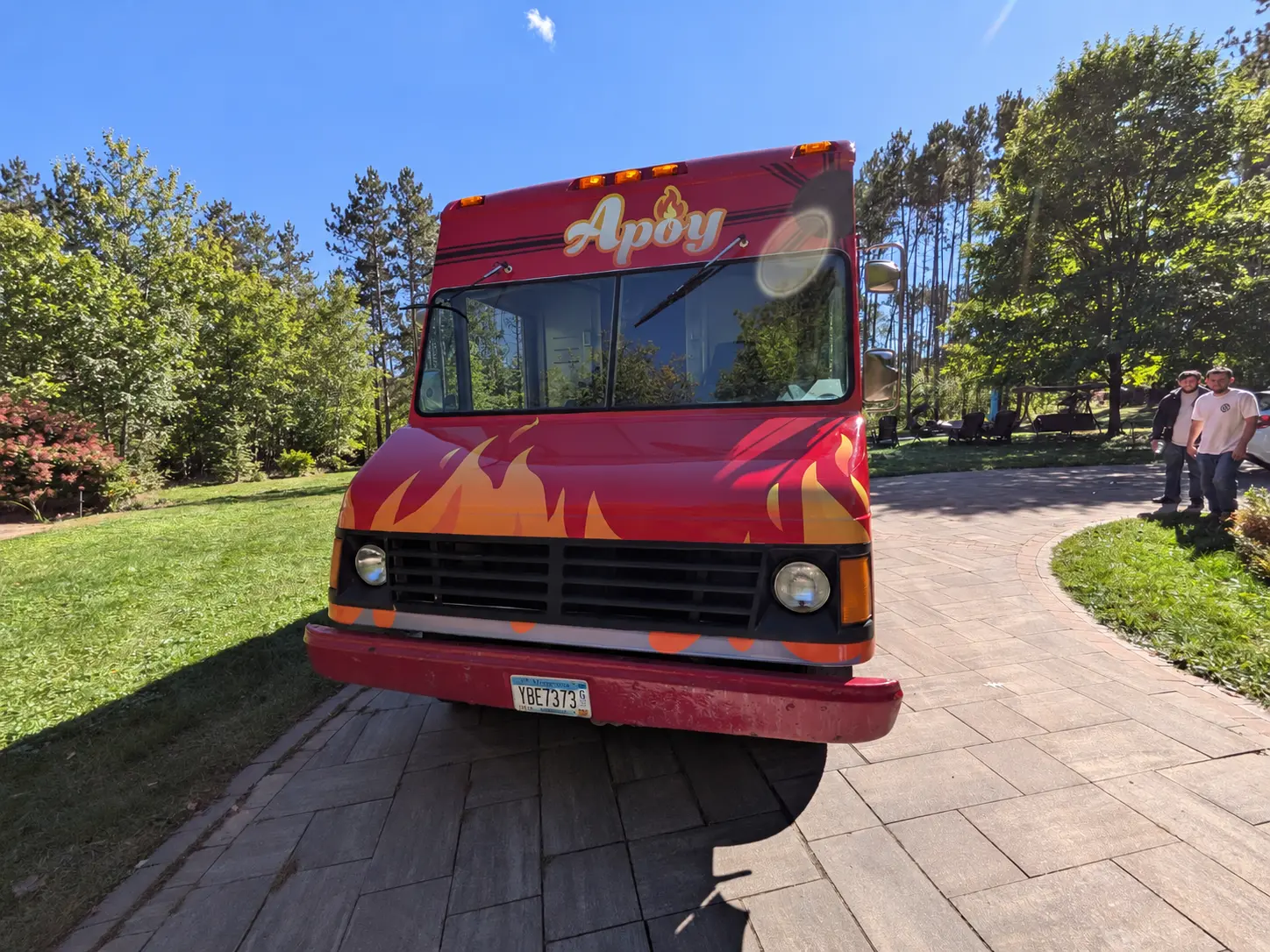 Front of the Apoy food truck with its logo above the windshield and flames across the hood