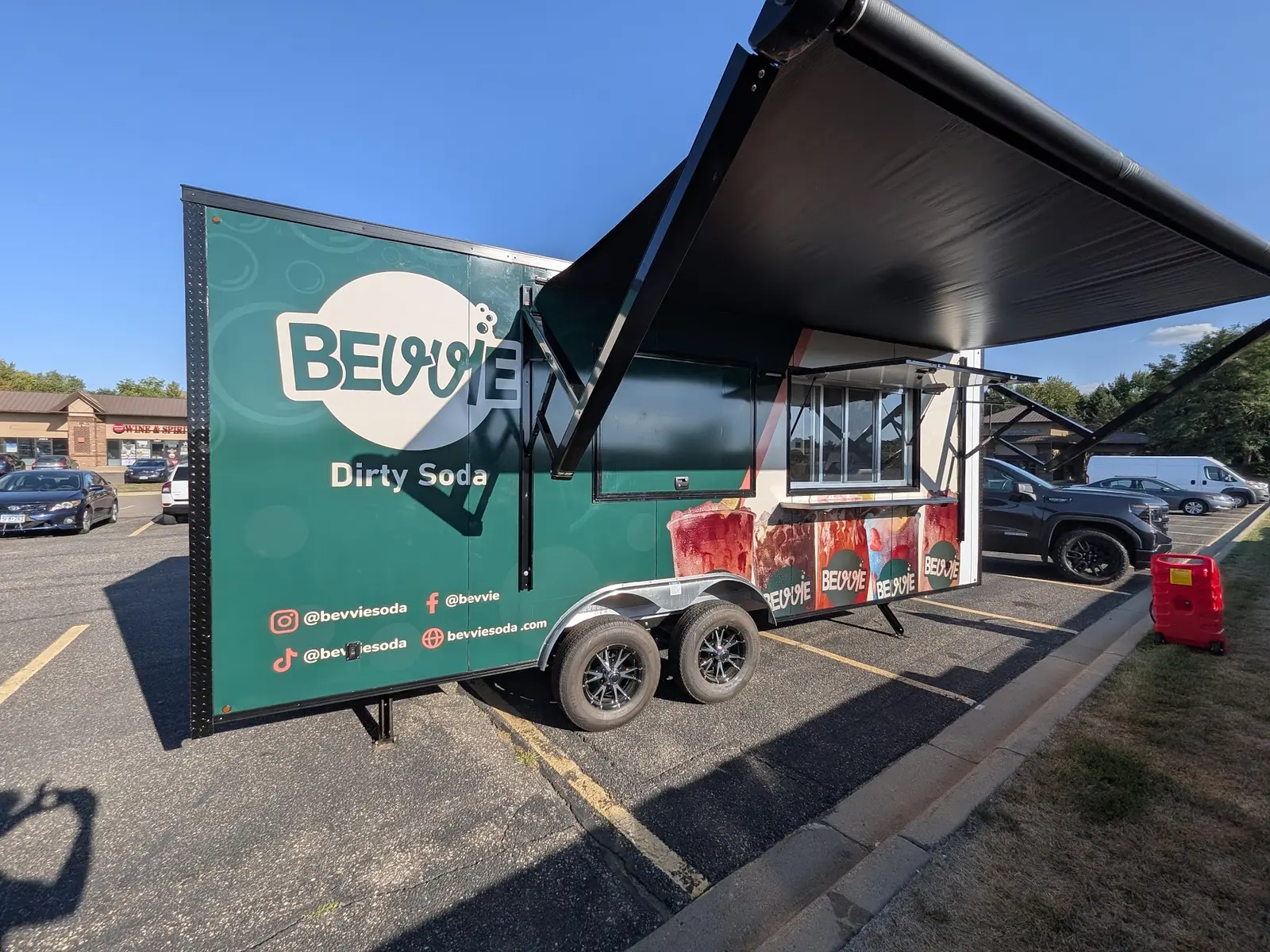 Green dirty soda trailer wrap with its serving awning open