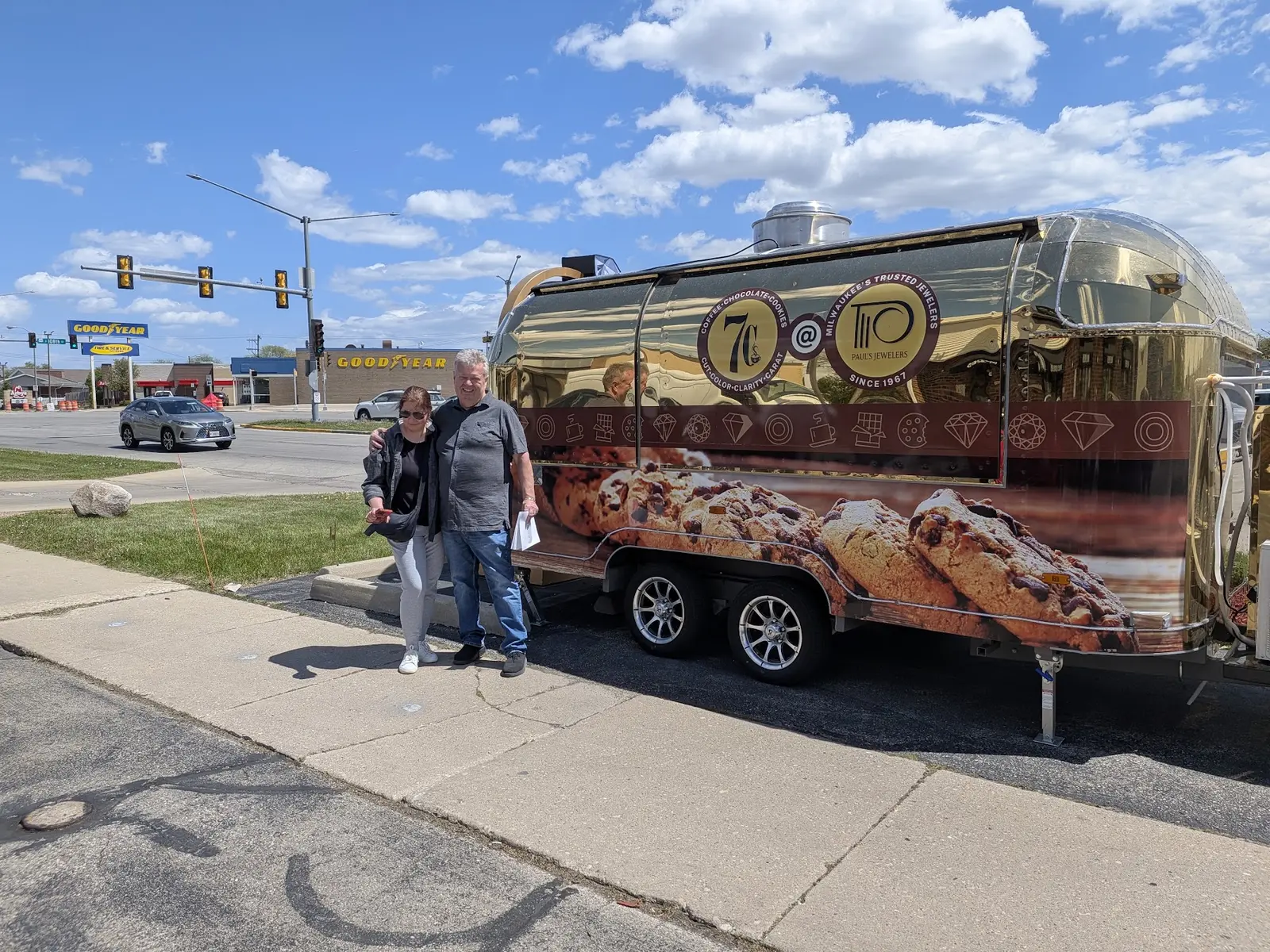 Fully wrapped mobile food trailer parked outdoors with its owner